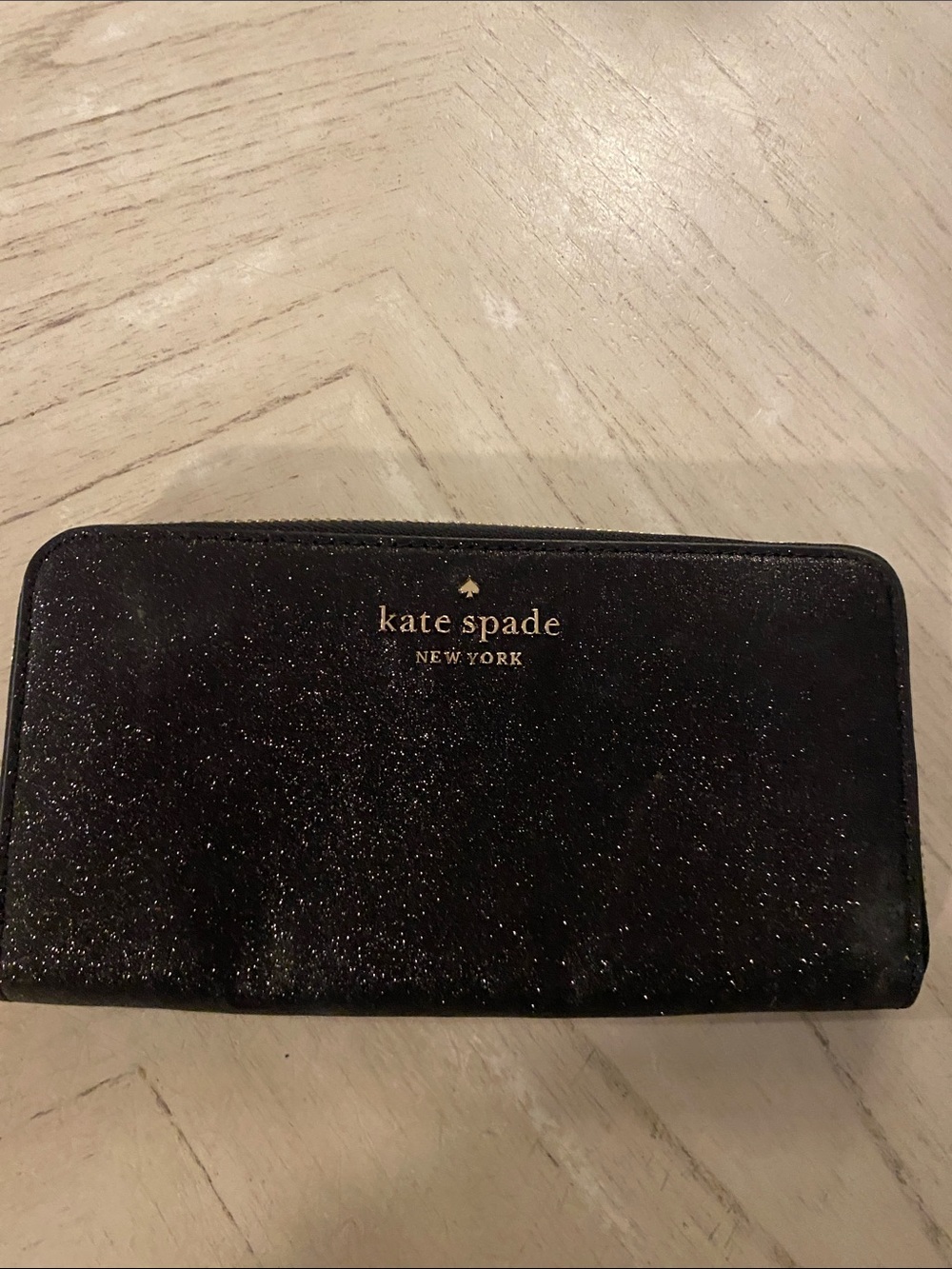 kate spade black glitter zip-around wallet with gold logo